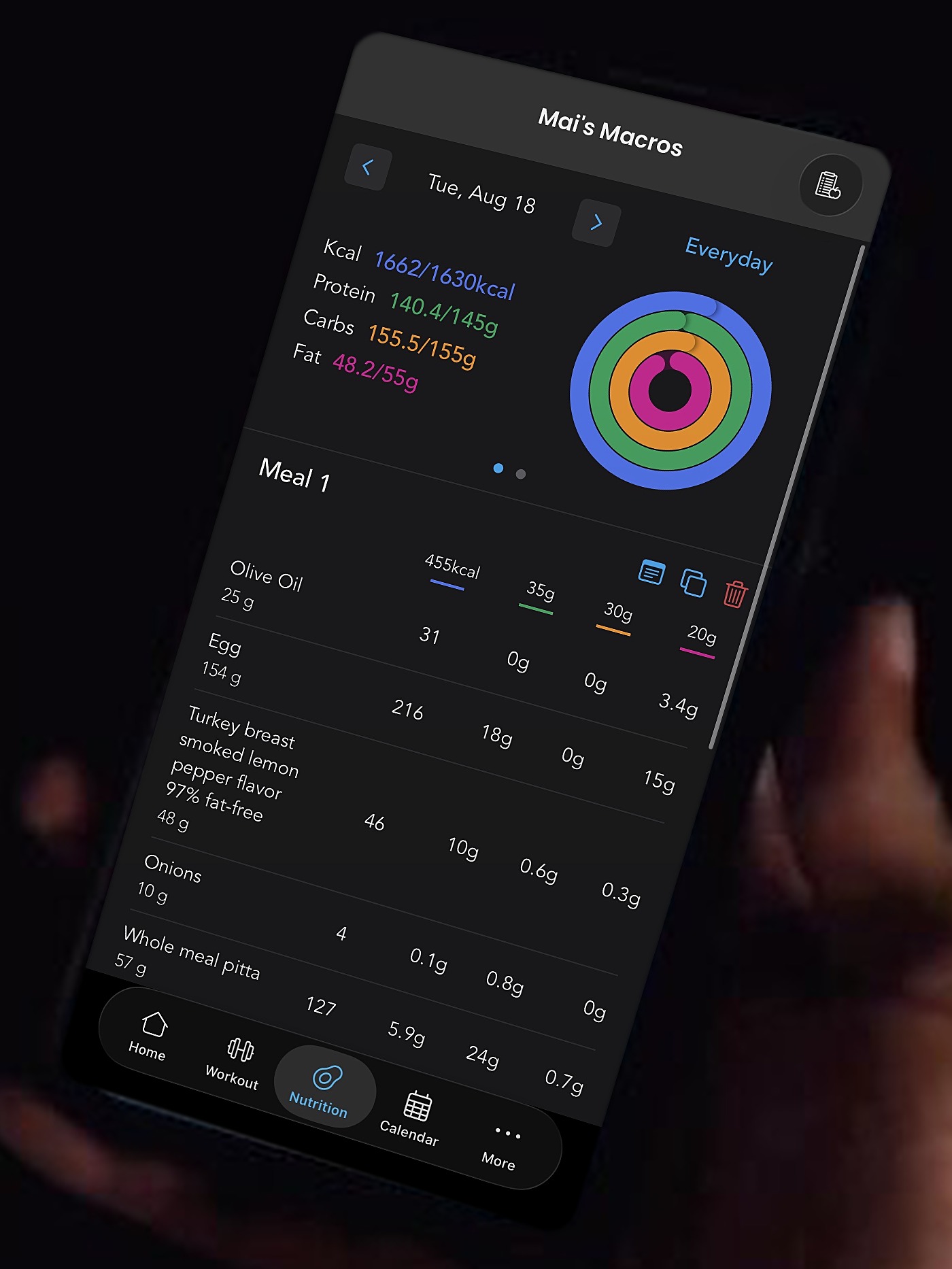 A hand holding a phone showing the Kahunas app with a client's daily macros and meal log